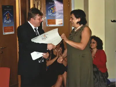 Un assessore della Regione del Veneto consegna a Paola Chiaramonte l'attestato del riconoscimento Marchio Famiglia