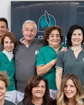 Andrea Recchia e Paola Chiaramonte al centro della squadra dello studio, nelle divise grigie e verde acqua, davanti al marchio