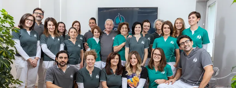 La squadra dello studio: ventidue persone nelle divise grigie e verde acqua, Andrea Recchia e Paola Chiaramonte al centro